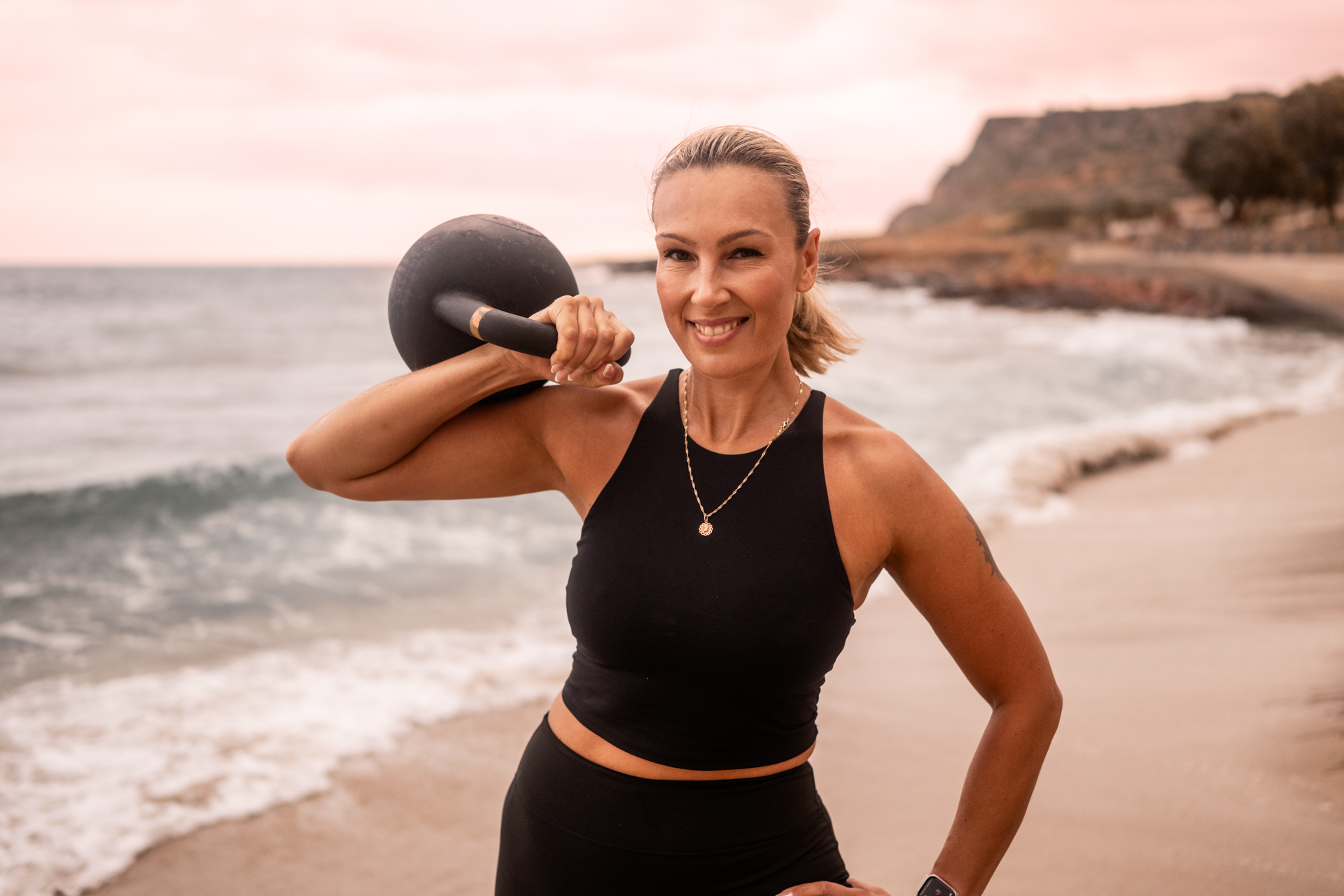 Personal Trainerin Monika Arent mit Kettlebell am Strand - Krafttraining und Fitness in Köln