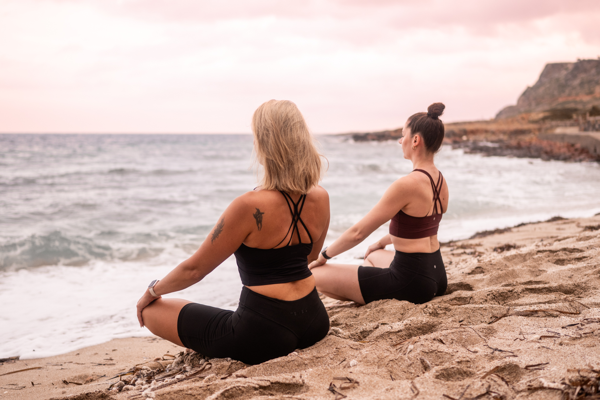Zwei Frauen sitzen entspannt am Meer und genießen einen ruhigen Moment am Strand. Entspannung und Achtsamkeit